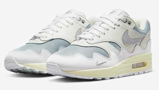 View of white and grey Nike Air Max 1 shoes.